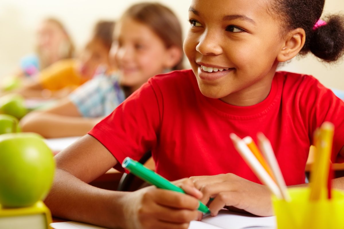 A smiling Escondido student drawing in class