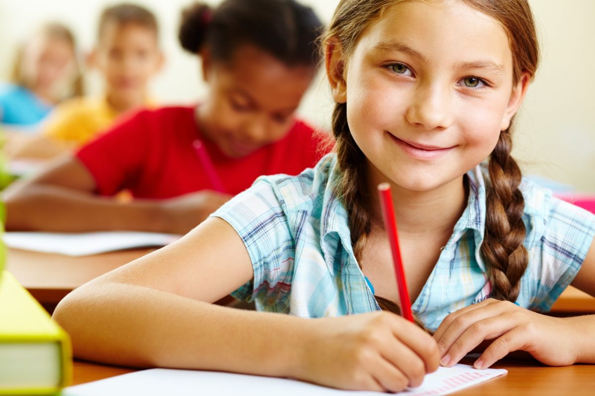 An Escondido student writing at her desk during class